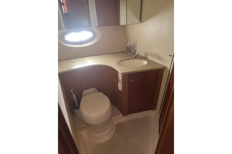 Slide: The Image of 2008 Silverton 36 Convertible yacht bathroom with toilet, sink, and porthole window. - 10