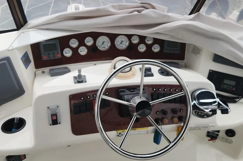 Slide: The Image of 2008 Silverton 36 Convertible boat dashboard with steering wheel and control gauges. - 13