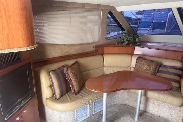 Slide: The Image of Interior of 2008 Silverton 36 Convertible yacht with cozy seating and wooden table. - 8