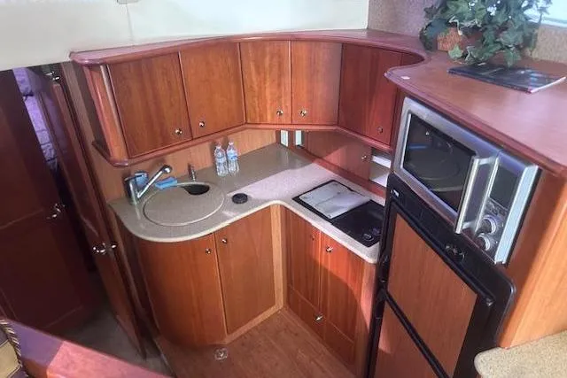 Slide: The Image of 2008 Silverton 36 Convertible yacht kitchen with wood cabinetry and modern appliances. - 9