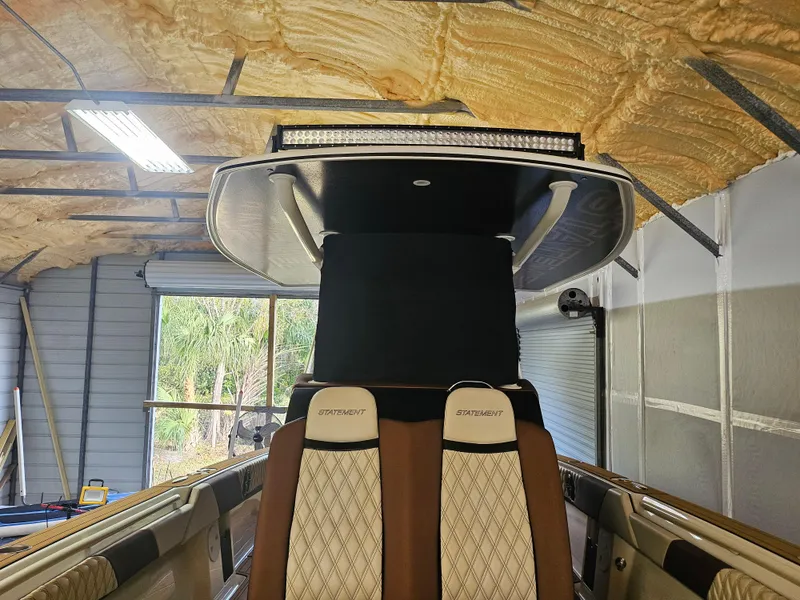 Slide: The Image of 2021 Statement 350 Open boat interior with luxury seating in a garage setting. - 15