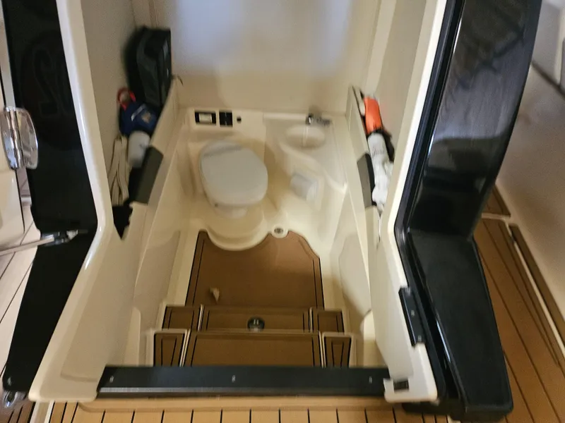 Slide: The Image of Interior of 2021 Statement 350 Open boat, featuring a compact marine toilet. - 18