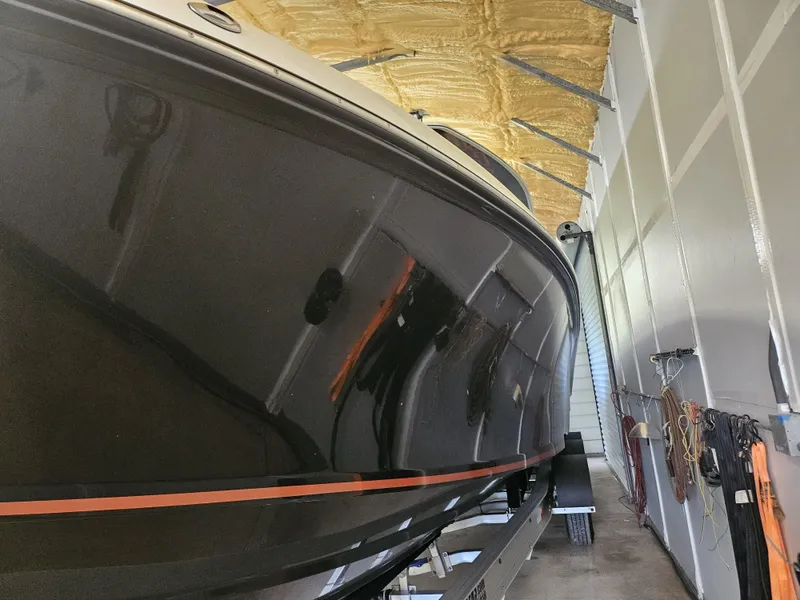 Slide: The Image of 2021 Statement 350 Open boat in storage, sleek black hull with orange stripe. - 36