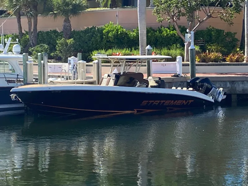 Slide: The Image of 2021 Statement 350 Open boat docked by lush greenery and waterfront. - 38