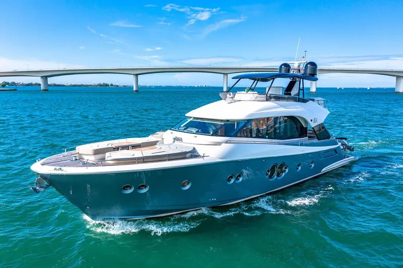 Slide: The Image of 2018 Monte Carlo Yachts MCY 70 cruising on blue waters near a bridge. - 1