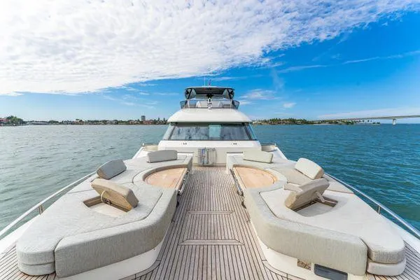 Slide: The Image of 2018 Monte Carlo Yachts MCY 70 on open water, featuring spacious deck and seating. - 21