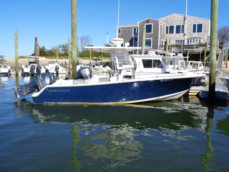 The Image of 2014 Sportsman Heritage 251 Center Console boat docked at marina. - 0