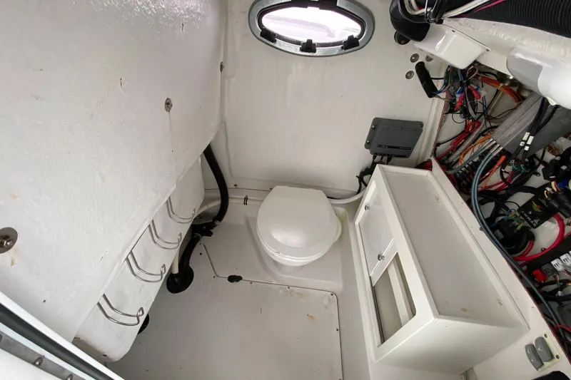 Slide: The Image of Interior of 2014 Sportsman Heritage 251 Center Console boat with toilet and wiring. - 18