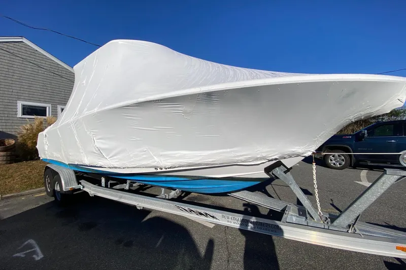 Slide: The Image of 2014 Sportsman Heritage 251 Center Console boat covered on trailer, parked outdoors. - 19