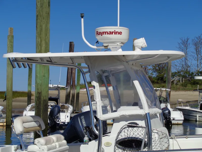 Slide: The Image of 2014 Sportsman Heritage 251 Center Console with Raymarine radar at a marina. - 2