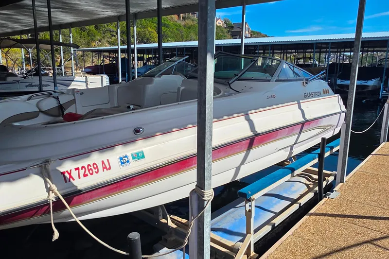 The Image of 2005 Glastron DX 235 boat docked in a marina, side view. - 1