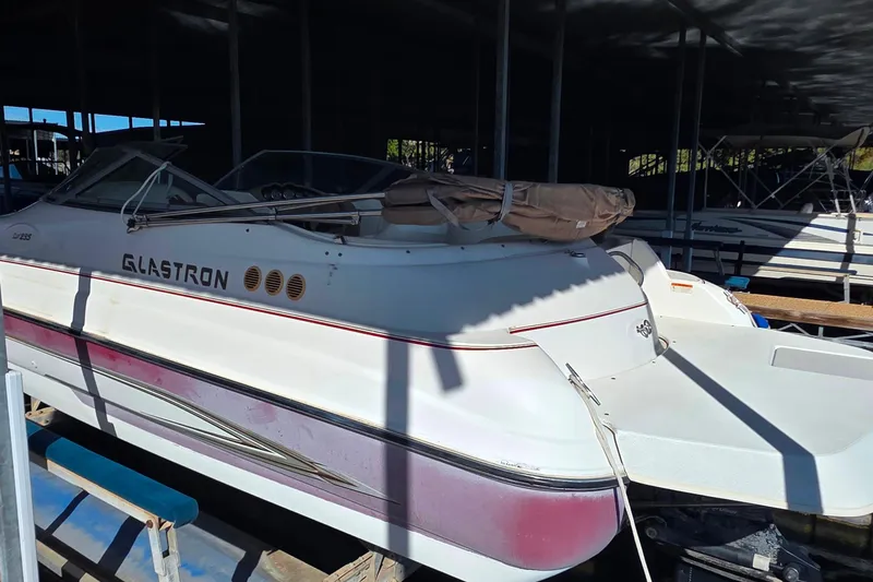 Slide: The Image of 2005 Glastron DX 235 boat docked in a marina under shade. - 5