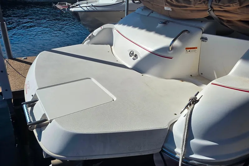 Slide: The Image of 2005 Glastron DX 235 boat stern with swim platform, docked on calm water. - 7