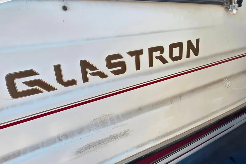 Slide: The Image of 2005 Glastron DX 235 boat side view with logo and red stripe. - 9