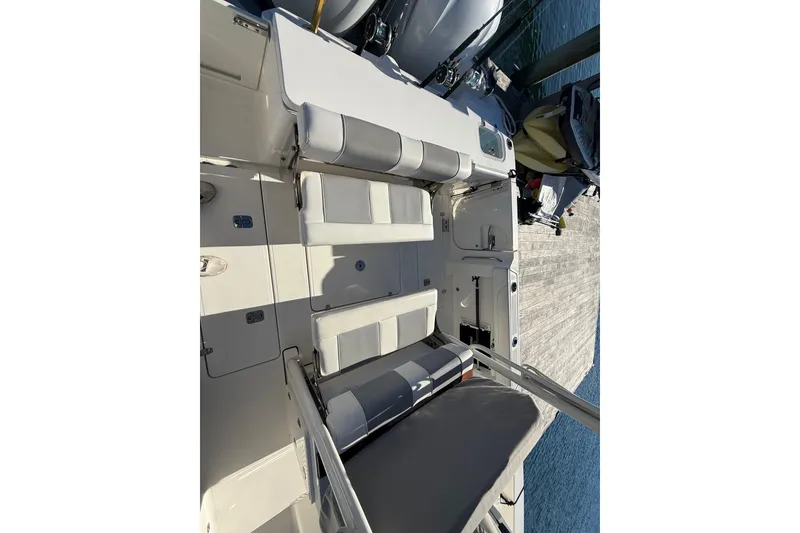 Slide: The Image of 2020 Pursuit S 288 Sport boat interior with cushioned seating and deck view. - 13