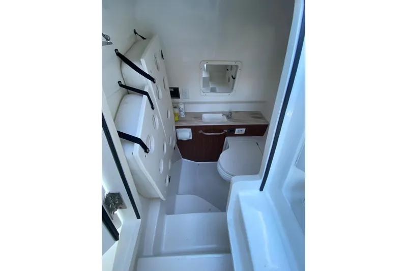 Slide: The Image of Interior of 2020 Pursuit S 288 Sport boat, featuring compact bathroom amenities. - 17