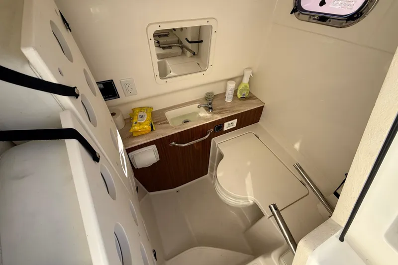 Slide: The Image of 2020 Pursuit S 288 Sport boat bathroom with sink, mirror, and storage. - 18