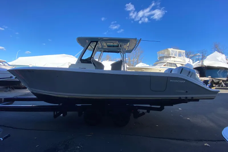 Slide: The Image of 2020 Pursuit S 288 Sport boat on trailer under clear blue sky. - 2