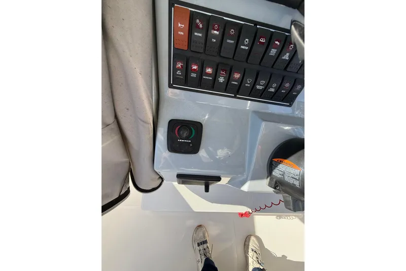 Slide: The Image of Control panel of a 2020 Pursuit S 288 Sport boat with switches and warning label. - 24