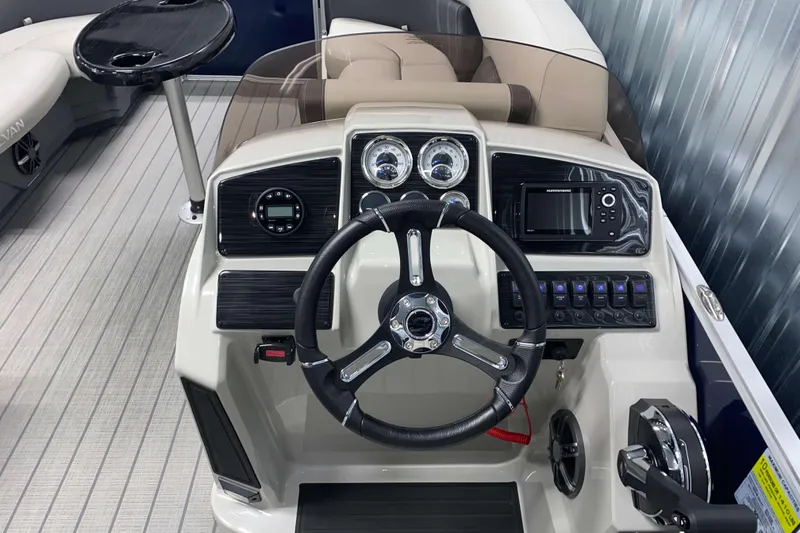 Slide: The Image of 2026 Sylvan Mirage Fish 8520 Party Fish boat dashboard with steering wheel and controls. - 8