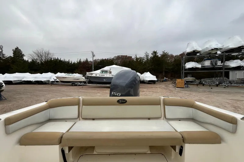 Slide: The Image of 2015 Scout 210 Dorado boat in storage yard with covered boats and trees. - 11