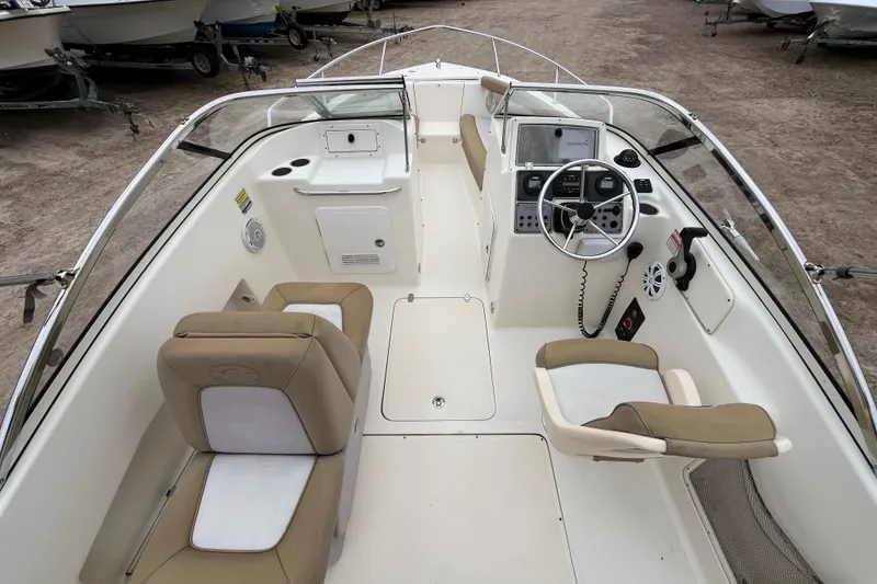 Slide: The Image of 2015 Scout 210 Dorado boat interior with beige seating and steering console. - 13