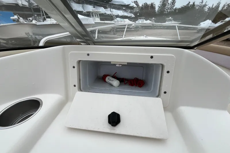 Slide: The Image of Open storage compartment on 2015 Scout 210 Dorado boat dashboard with safety gear. - 19