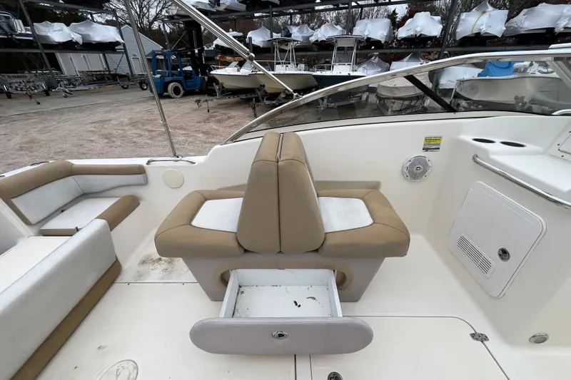 Slide: The Image of 2015 Scout 210 Dorado boat interior with beige seating and storage compartment. - 20