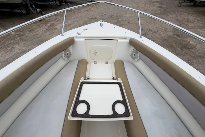Slide: The Image of 2015 Scout 210 Dorado boat interior with cushioned seating and storage compartment. - 21