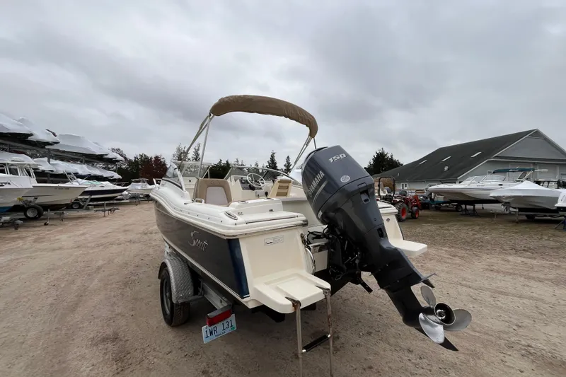 Slide: The Image of 2015 Scout 210 Dorado boat on trailer, overcast sky, parked outdoors. - 4