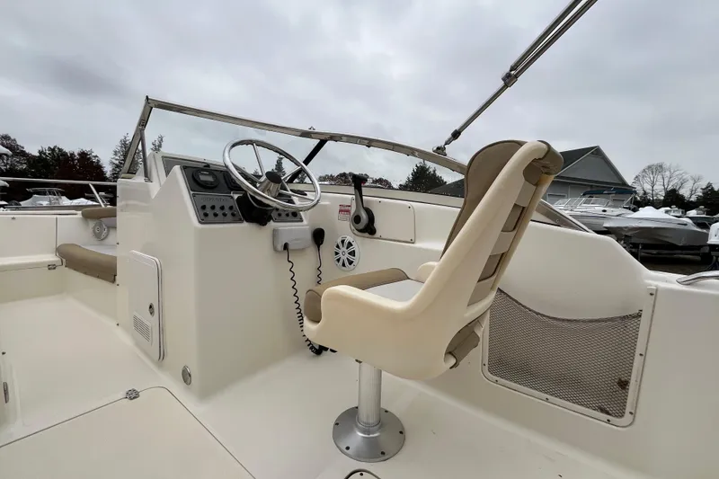 Slide: The Image of 2015 Scout 210 Dorado boat interior with steering wheel and captain's chair. - 9