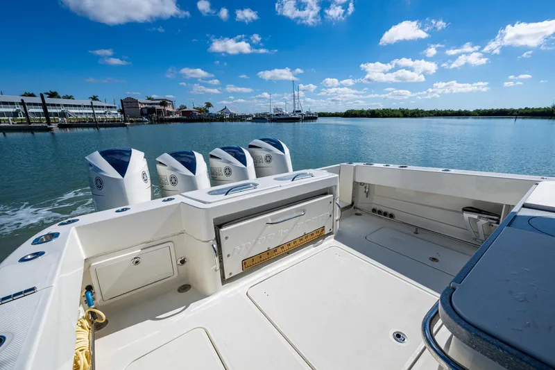 Slide: The Image of Four Yamaha outboard engines on a 2018 HCB 42 Siesta boat, docked by waterfront homes. - 11
