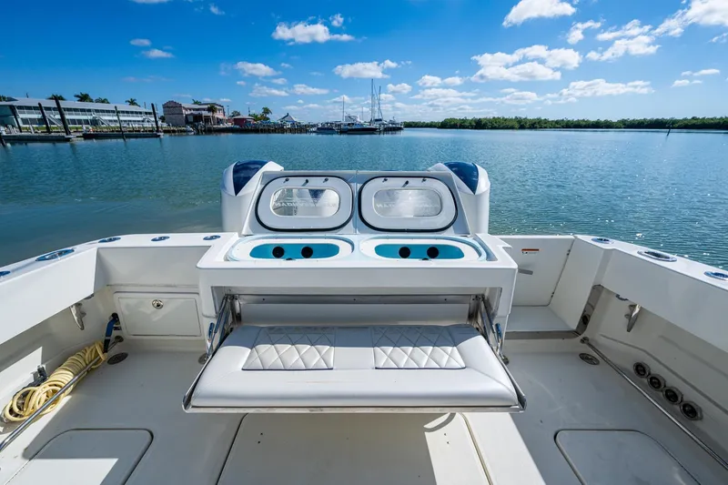 Slide: The Image of 2018 HCB 42 Siesta boat with quad engines docked in a marina under a clear blue sky. - 13