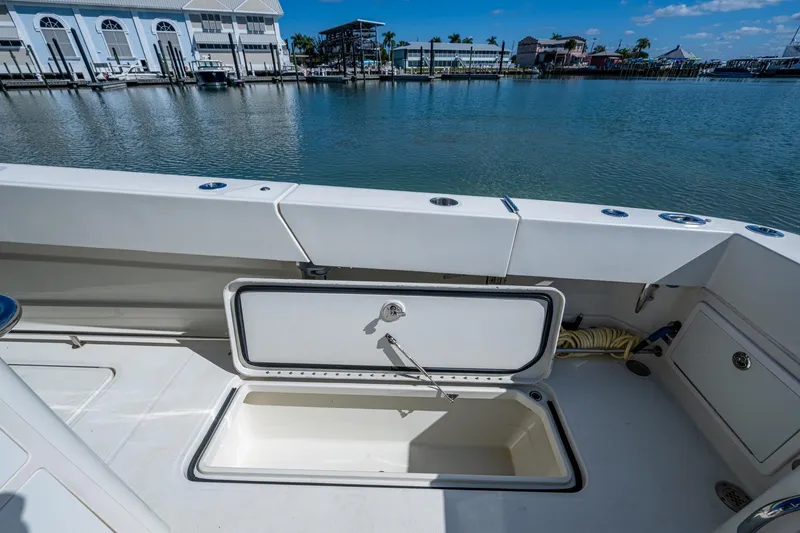 Slide: The Image of 2018 HCB 42 Siesta boat with open storage compartment by the water. - 17