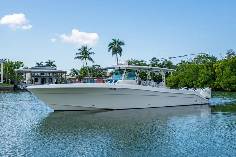 Slide: The Image of 2018 HCB 42 Siesta boat on calm water with palm trees in the background. - 43