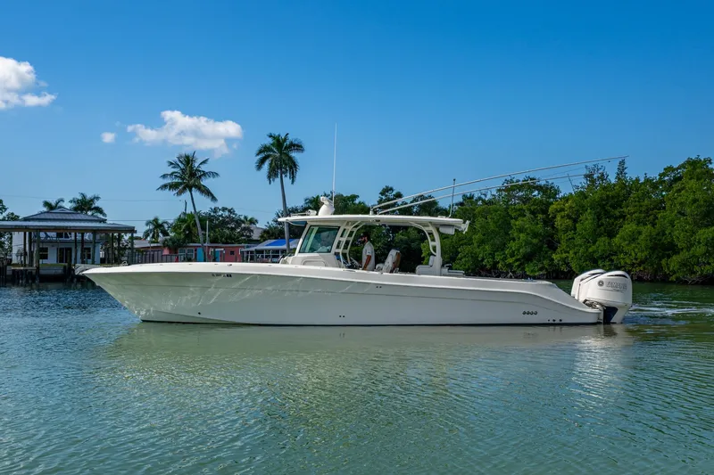 Slide: The Image of 2018 HCB 42 Siesta boat on calm water, surrounded by palm trees and clear blue sky. - 46