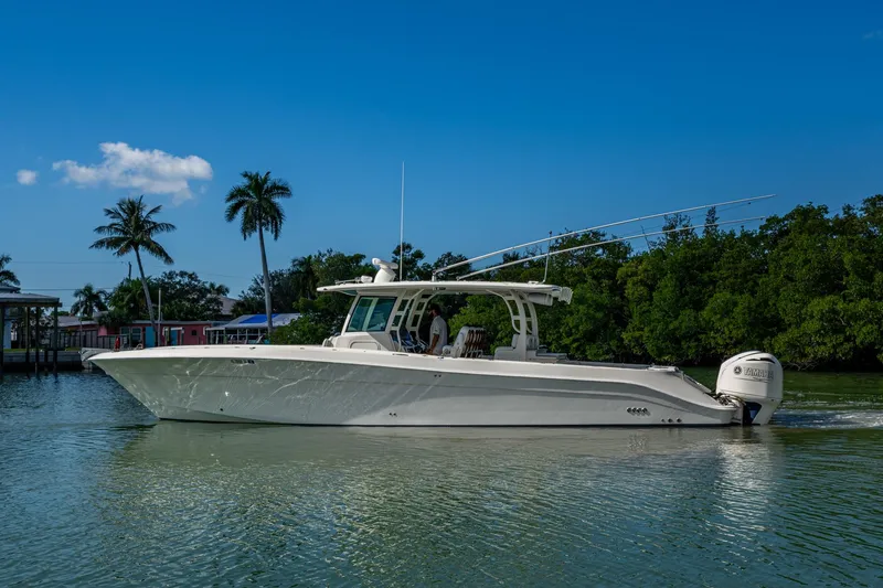 Slide: The Image of 2018 HCB 42 Siesta boat cruising on a sunny day with palm trees in the background. - 47