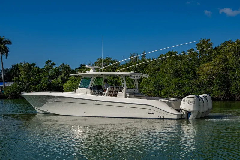 Slide: The Image of 2018 HCB 42 Siesta boat cruising on a calm river with lush greenery. - 49