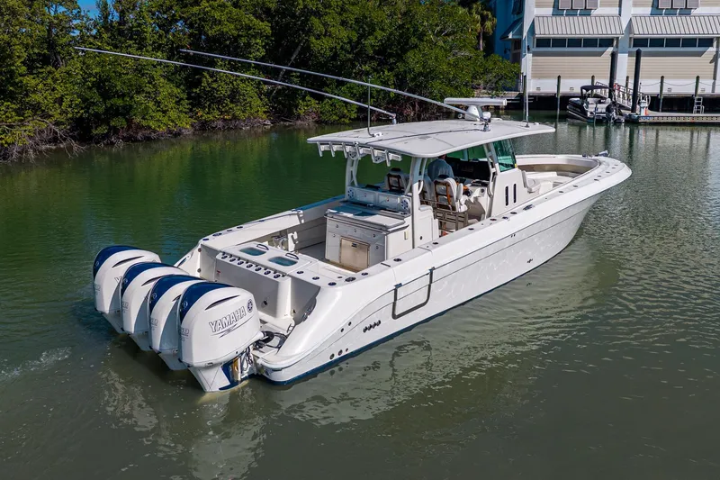 Slide: The Image of 2018 HCB 42 Siesta boat with Yamaha engines on calm water near trees. - 5