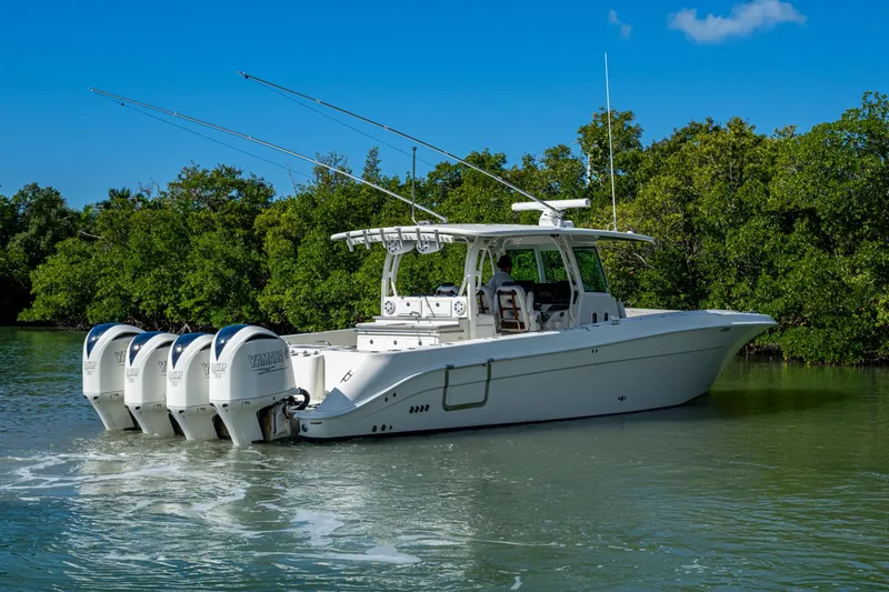 Slide: The Image of 2018 HCB 42 Siesta boat with four Yamaha engines on a calm waterway. - 54