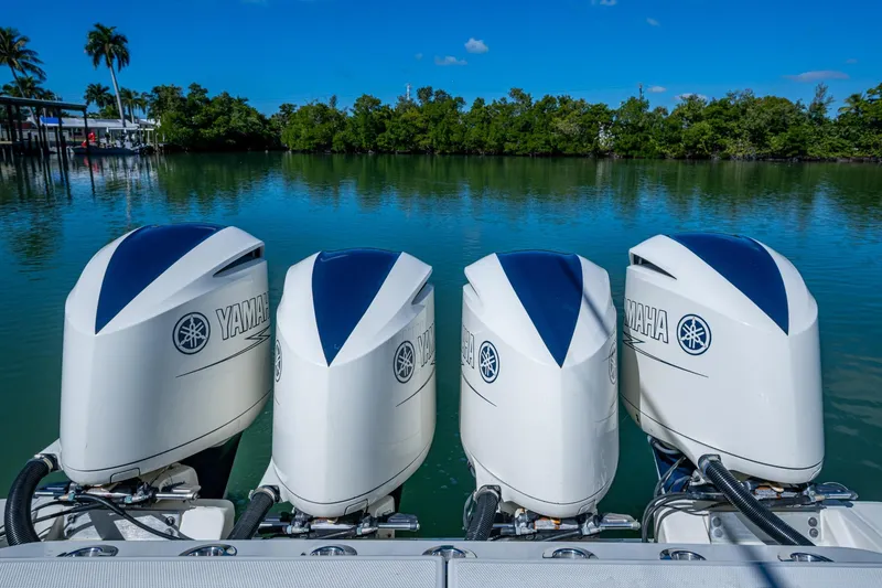 Slide: The Image of Four Yamaha outboard engines on a 2018 HCB 42 Siesta boat, docked by a serene lake. - 9