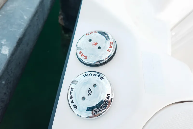 Slide: The Image of 2007 Boston Whaler 305 Conquest gas and waste caps on boat deck. - 10