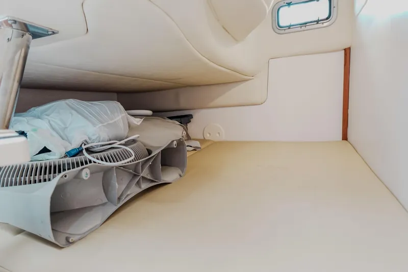 Slide: The Image of 2007 Boston Whaler 305 Conquest cabin interior with fan and bedding. - 13