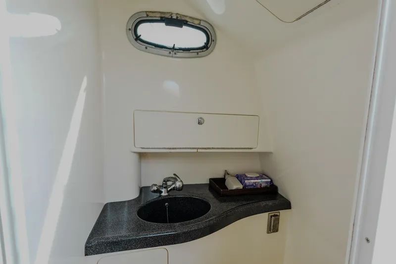 Slide: The Image of 2007 Boston Whaler 305 Conquest boat interior with sink and storage compartment. - 14