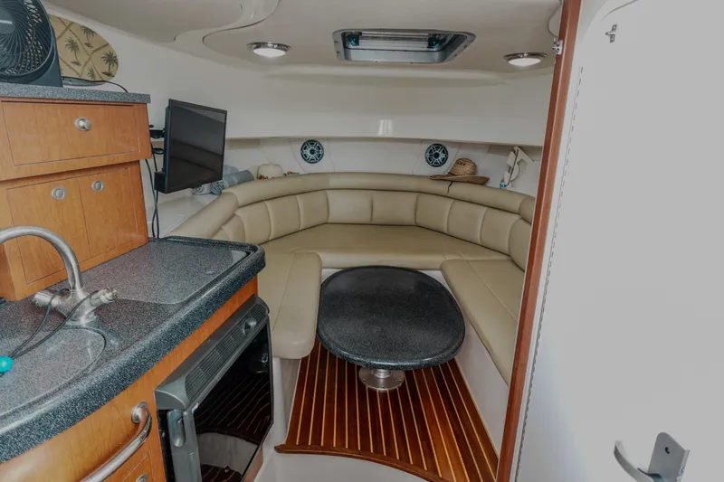 Slide: The Image of 2007 Boston Whaler 305 Conquest cabin interior with seating, kitchenette, and modern amenities. - 16