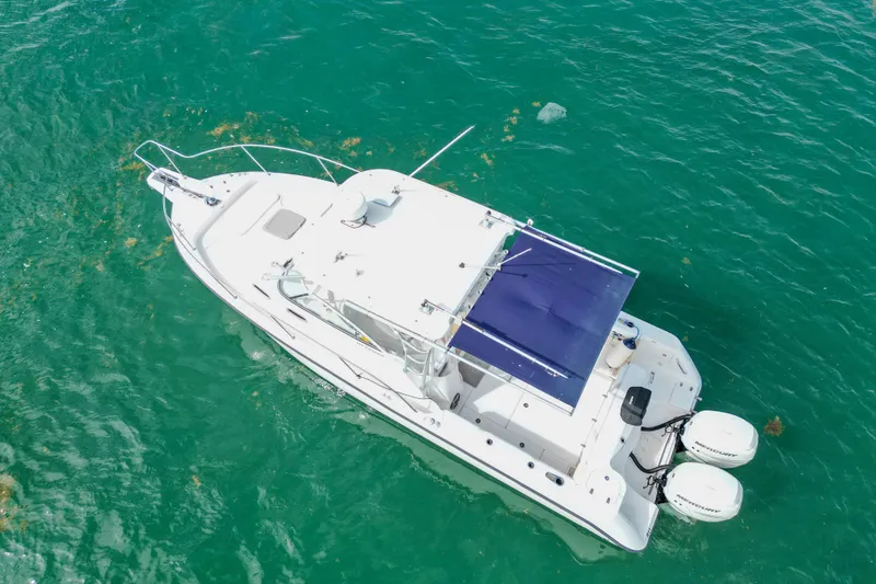 Slide: The Image of 2007 Boston Whaler 305 Conquest boat on clear turquoise water, aerial view. - 2