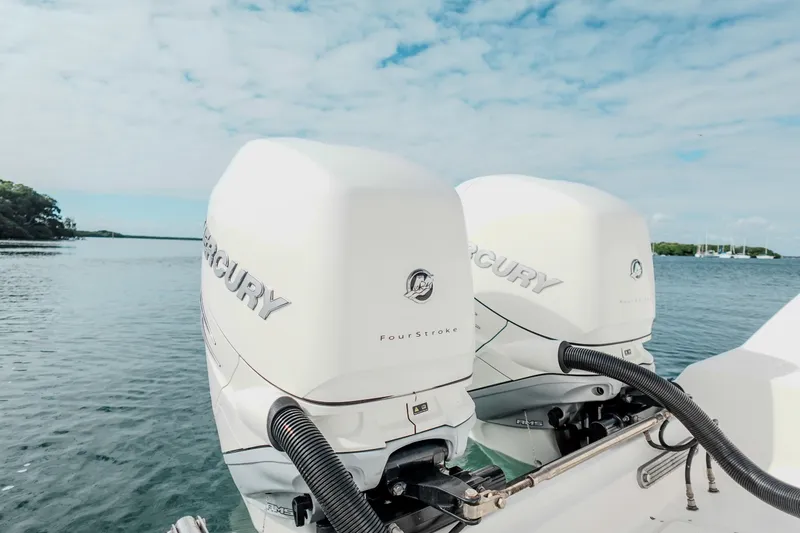 Slide: The Image of Twin Mercury FourStroke engines on a 2007 Boston Whaler 305 Conquest boat, scenic water backdrop. - 23