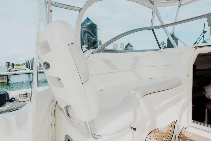 Slide: The Image of 2007 Boston Whaler 305 Conquest interior with white seating and open cabin door. - 26