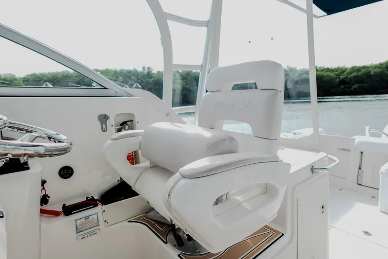 Slide: The Image of 2007 Boston Whaler 305 Conquest helm seat and steering wheel, overlooking serene waters. - 28