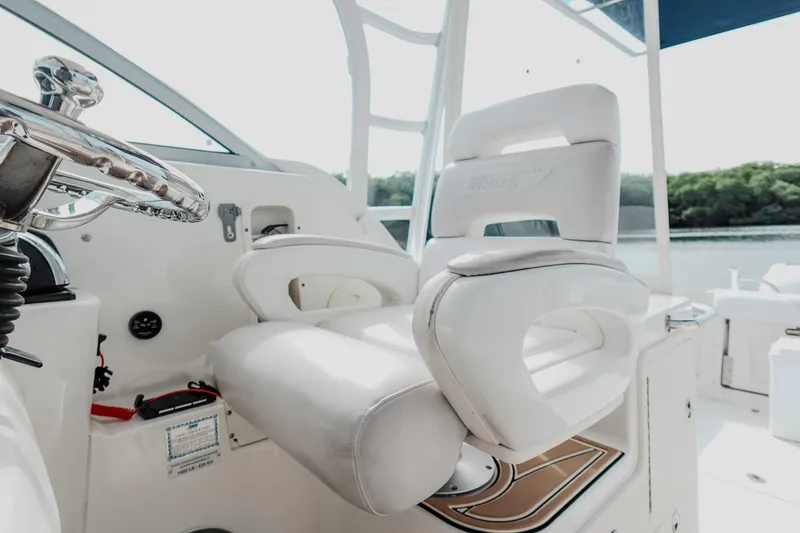Slide: The Image of 2007 Boston Whaler 305 Conquest helm with white captain's chair and steering wheel. - 29